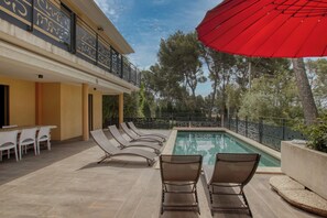 A poolside area with lounge chairs and a red umbrella. - Appartement Prestige vue mer et Piscine Privée (La Ciotat)