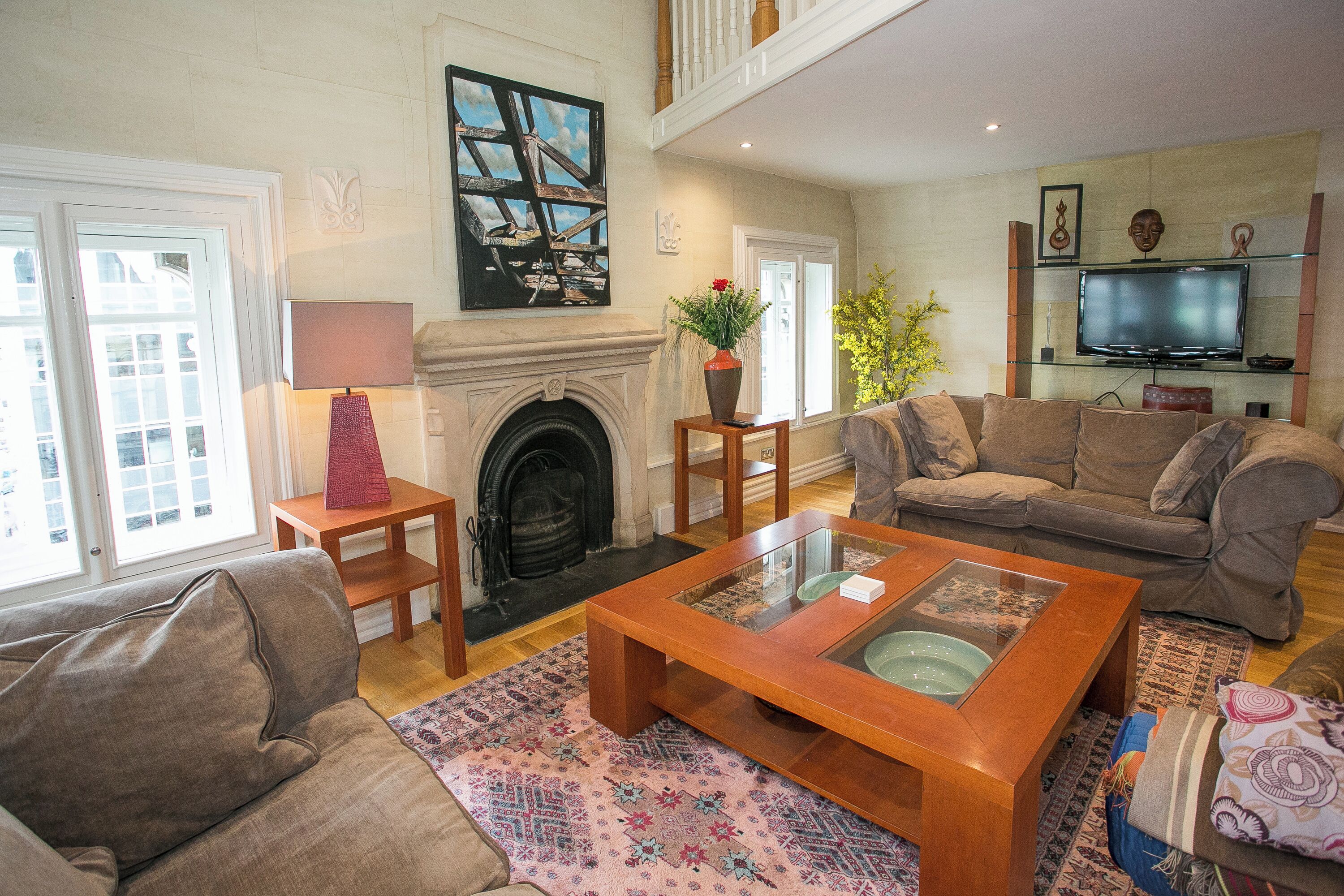 A spacious living room with a fireplace, a television, and comfortable seating.