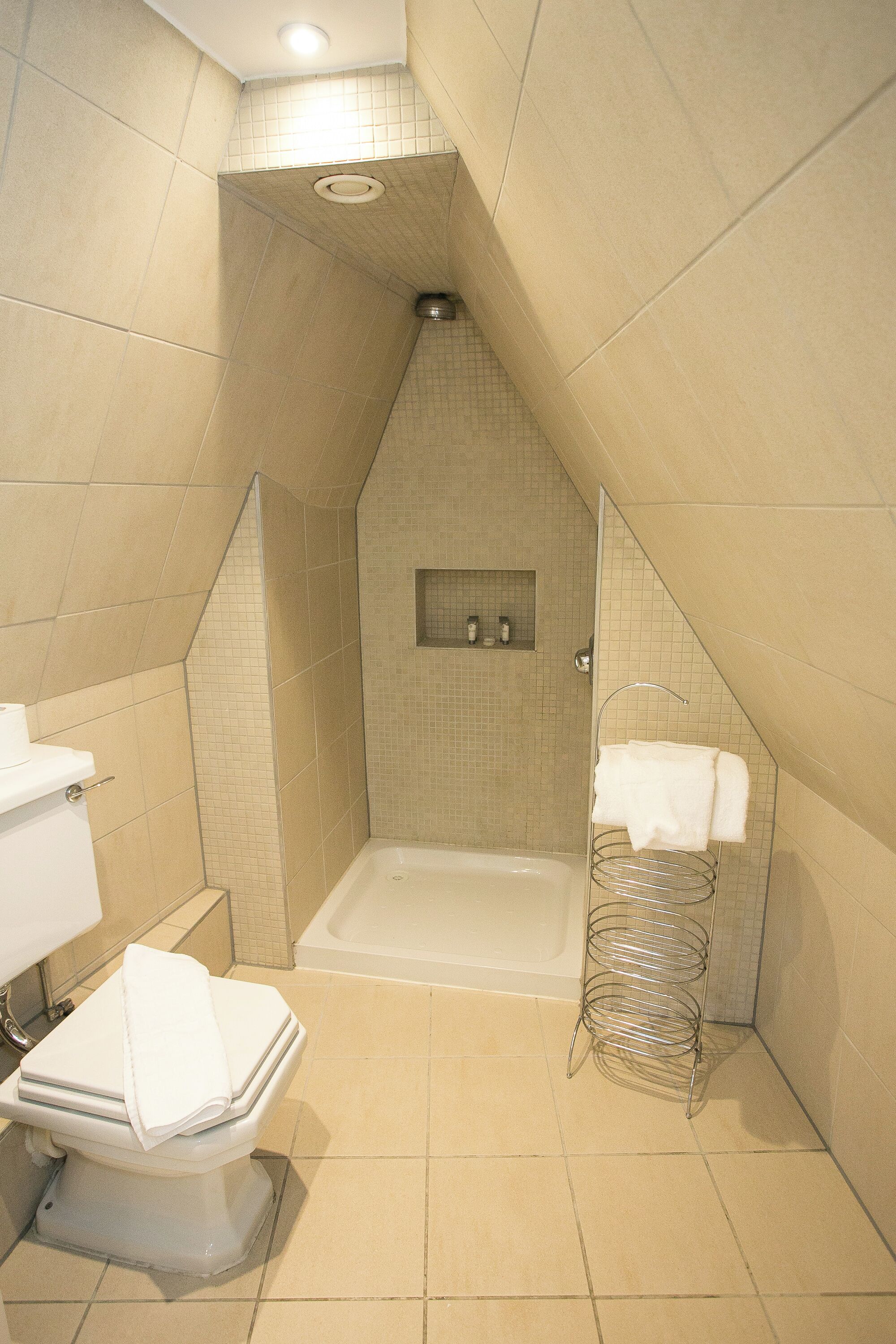 A bathroom with a bathtub, toilet, and shower area.