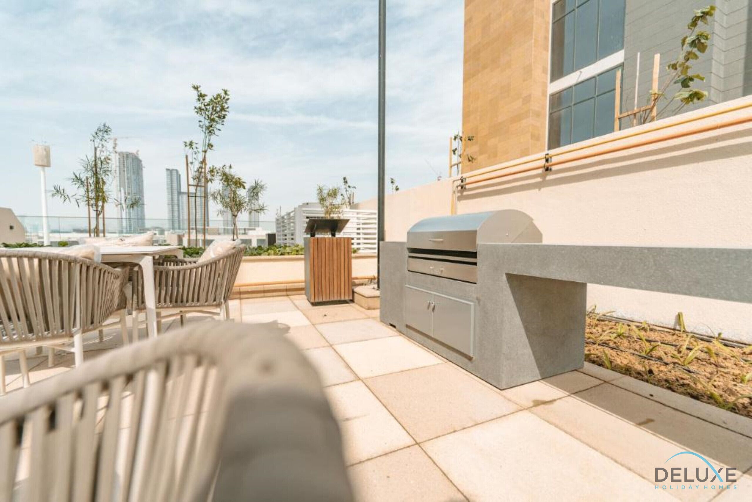 Eine Außenpatio mit Grill, Sitzgelegenheiten und Blick auf die Stadtlandschaft.
