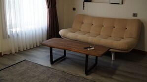 Un soggiorno con divano, tavolino in legno e tappeto.