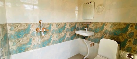 A bathroom with a toilet, sink, and shower.