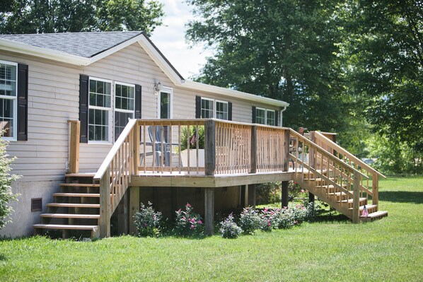 A two-story house with a wooden deck and stairs leading to a front door. - Trout House, Trout House 4bd/3ba on the South Holston River (Bristol)