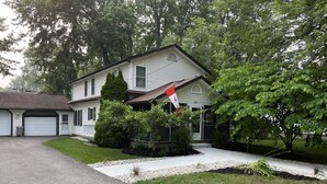 Ein zweigeschossiges Haus mit Garage, Auffahrt und einem gepflegten Rasen.