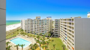 Un hôtel de grande hauteur doté de nombreux balcons, d’une piscine et offrant une vue sur la plage.