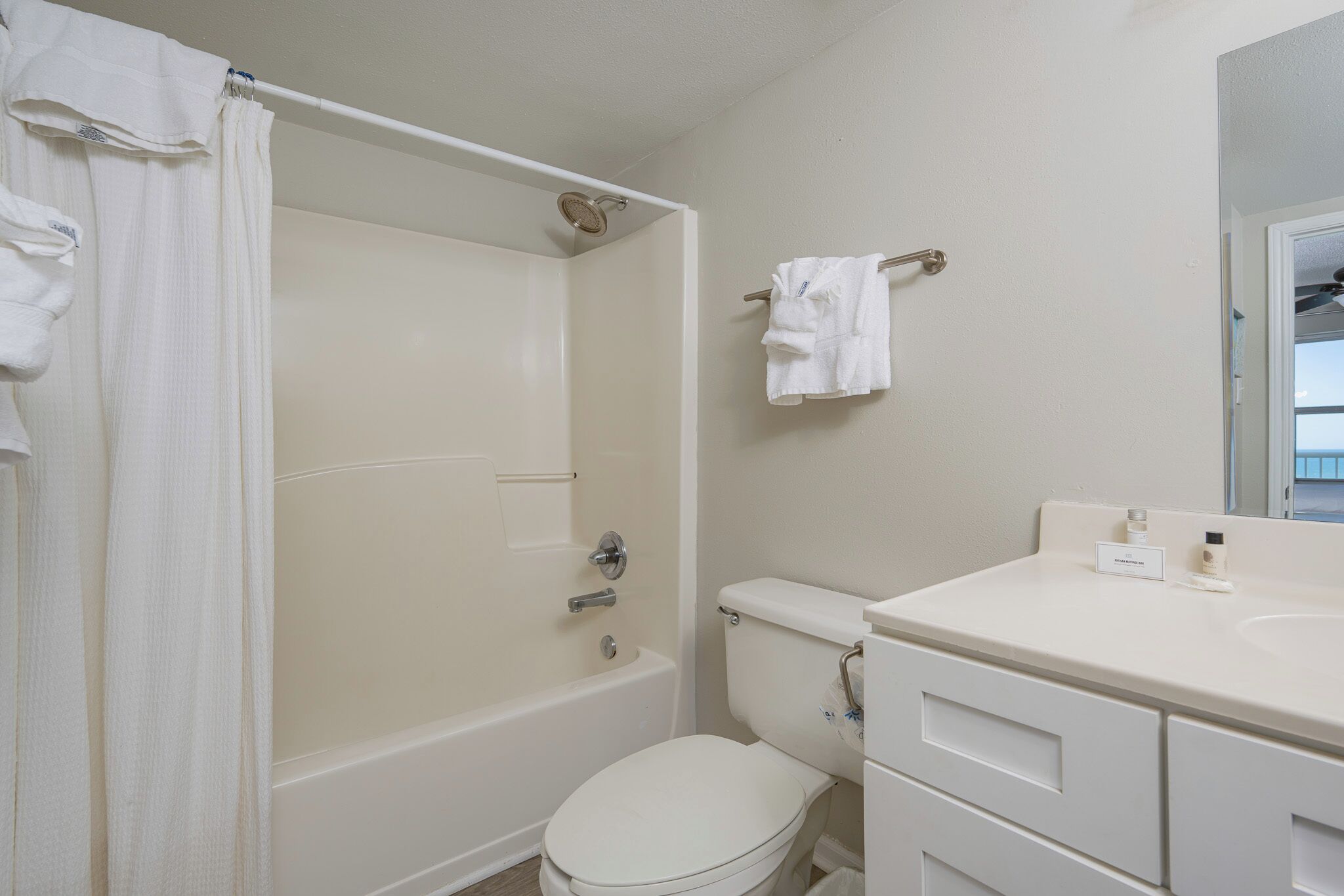 A bathroom with a bathtub, toilet, and a sink.