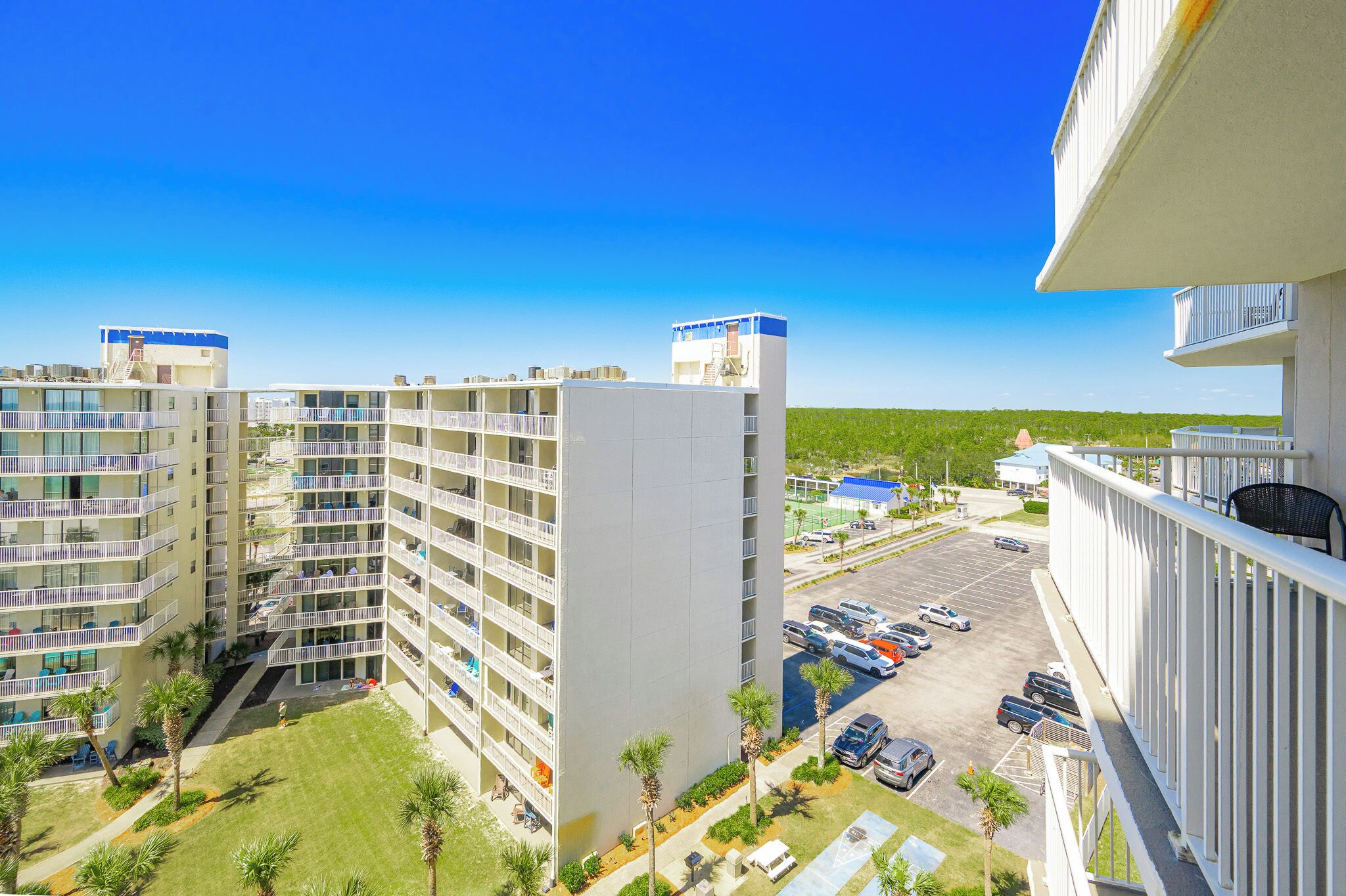 Un hôtel à plusieurs étages doté de balcons, d’un parking et offrant une vue dégagée sur les environs.