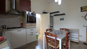 A compact kitchen with a stove, oven, and a dining area with a table and chairs.