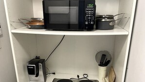 Uma cozinha com micro-ondas, torradeira e fogão.