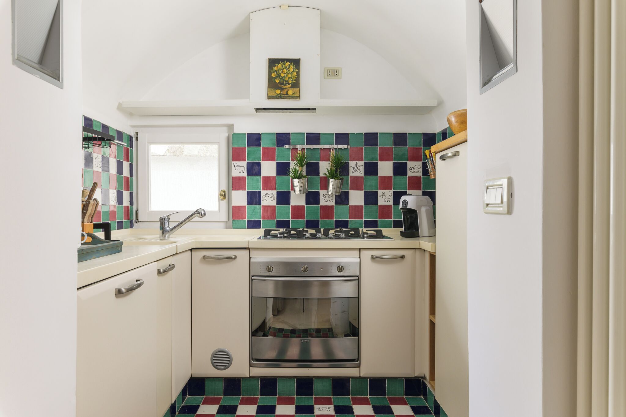 A compact kitchen with a tiled backsplash, a built-in oven, and a gas stove.