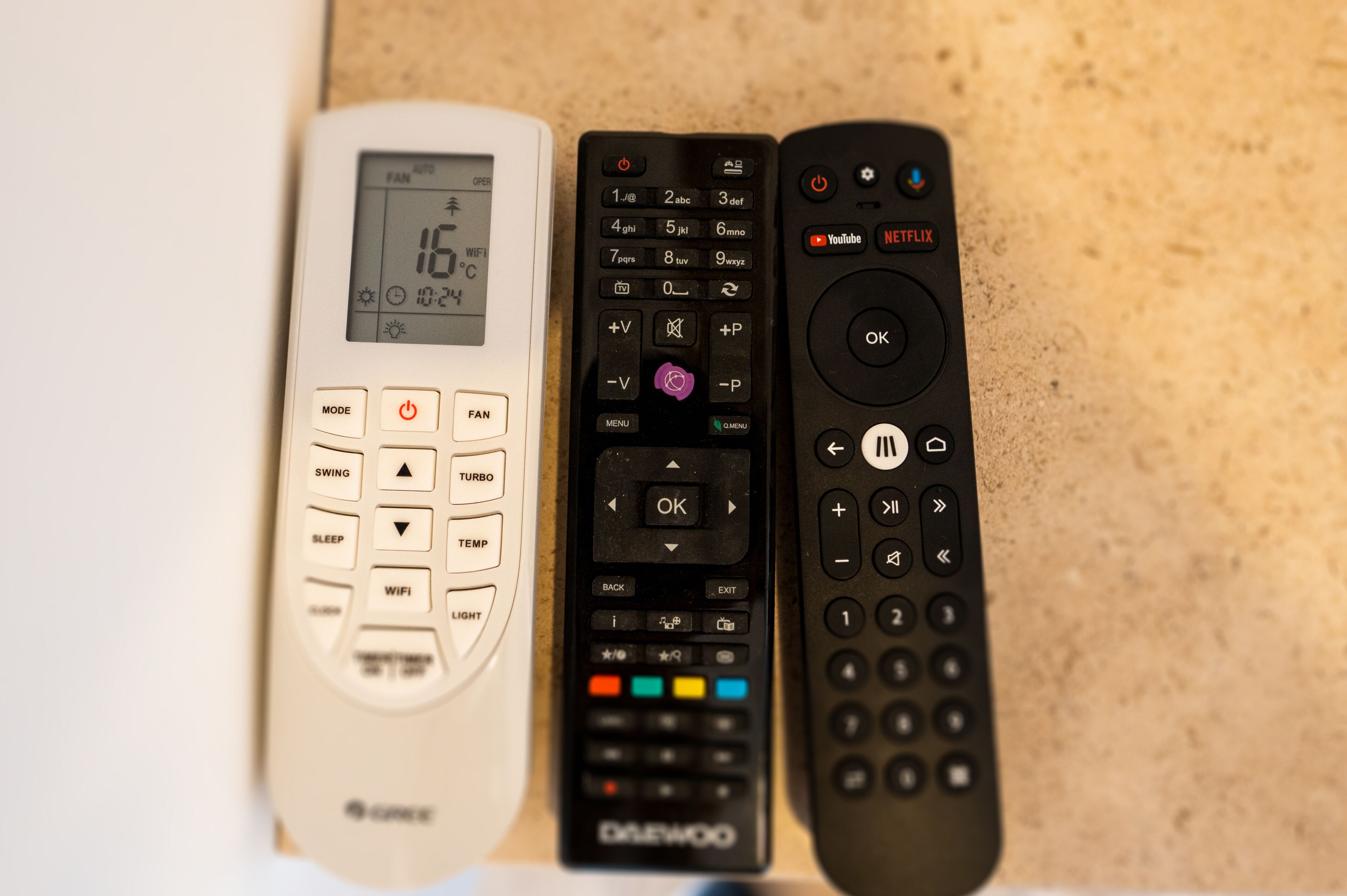 Three remote controls on a countertop.