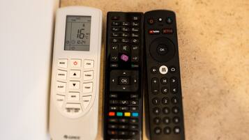 Three remote controls on a countertop.