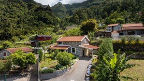 Un village perché sur une colline, avec des maisons en pierre, une route pavée et une végétation luxuriante.