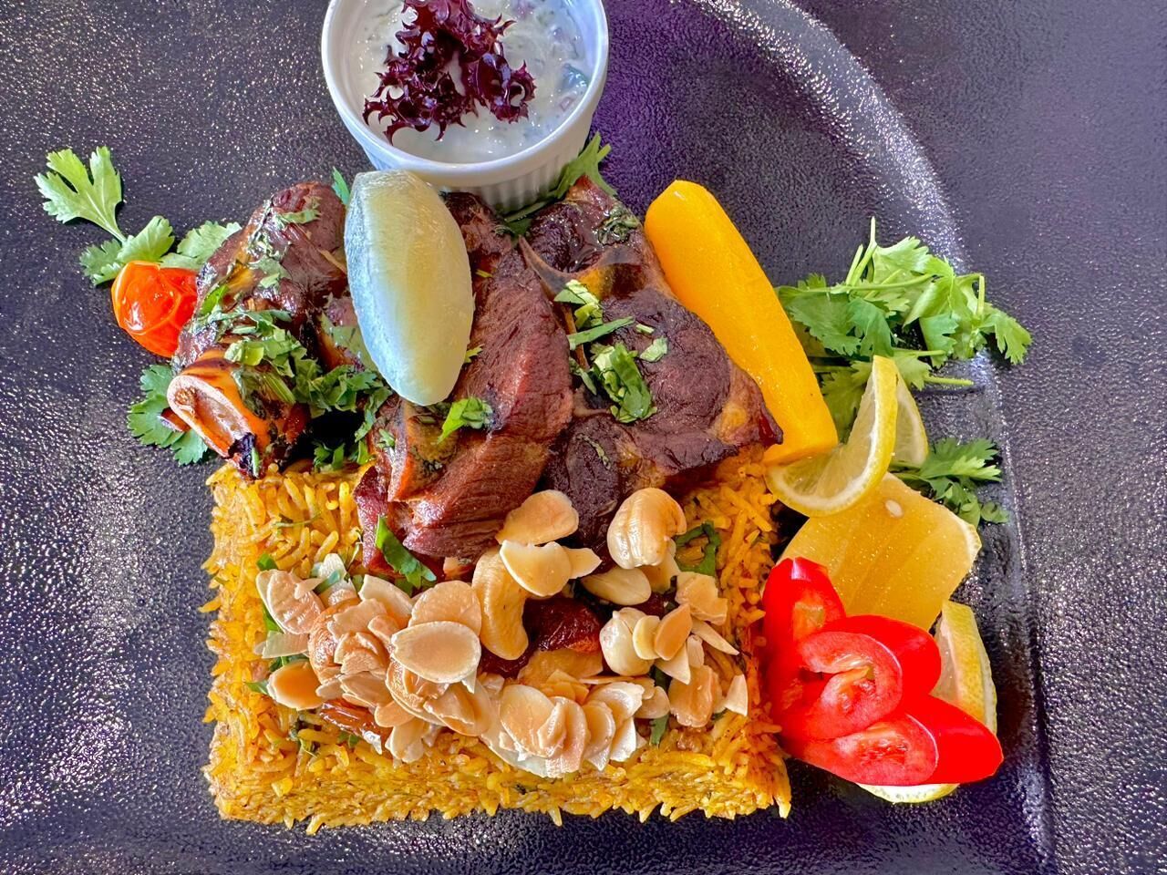 A plate of food with rice, meat, and vegetables.