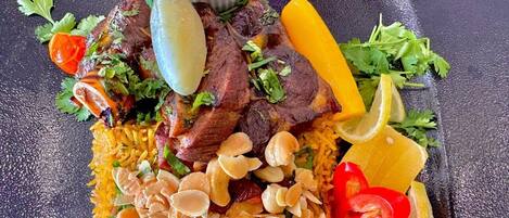 A plate of food with rice, meat, and vegetables.