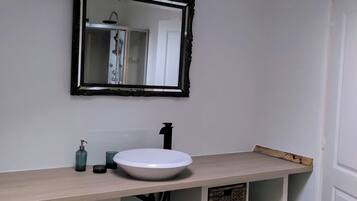 Een douche, handdoeken, zeep, toiletpapier