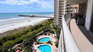 Ein Hochhaus-Hotel mit Pool, Blick auf den Strand und einer Mole.