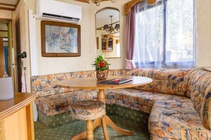 A cozy room with a floral sofa, a round wooden table, and a framed painting on the wall. - Base Camp for the Harz and City Tours Leipzig, Magdeburg, Dessau, Quedlinburg... (Gröbzig)