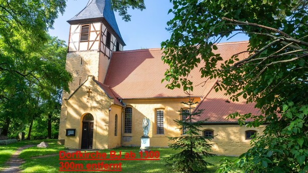 A church with a bell tower and a small statue in front. - Base Camp for the Harz and City Tours Leipzig, Magdeburg, Dessau, Quedlinburg... (Gröbzig)