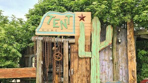 Une structure rustique en bois, sur laquelle est apposée une enseigne indiquant « TEN HOME ».