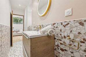 Ein modernes Badezimmer mit Marmorwaschtisch, Handtuchhalter und Spiegel.