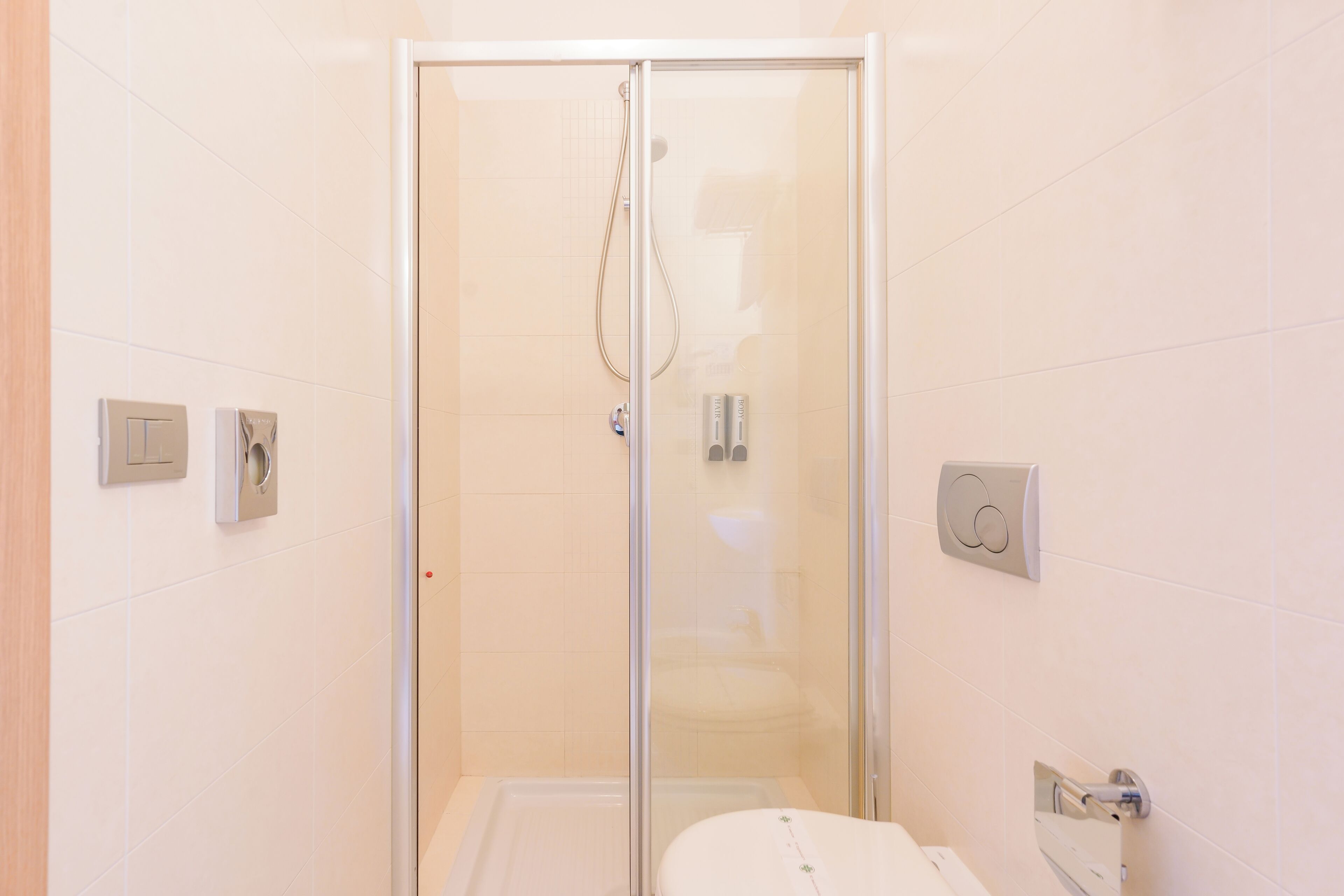 Un baño moderno con ducha acristalada, inodoro y lavabo.