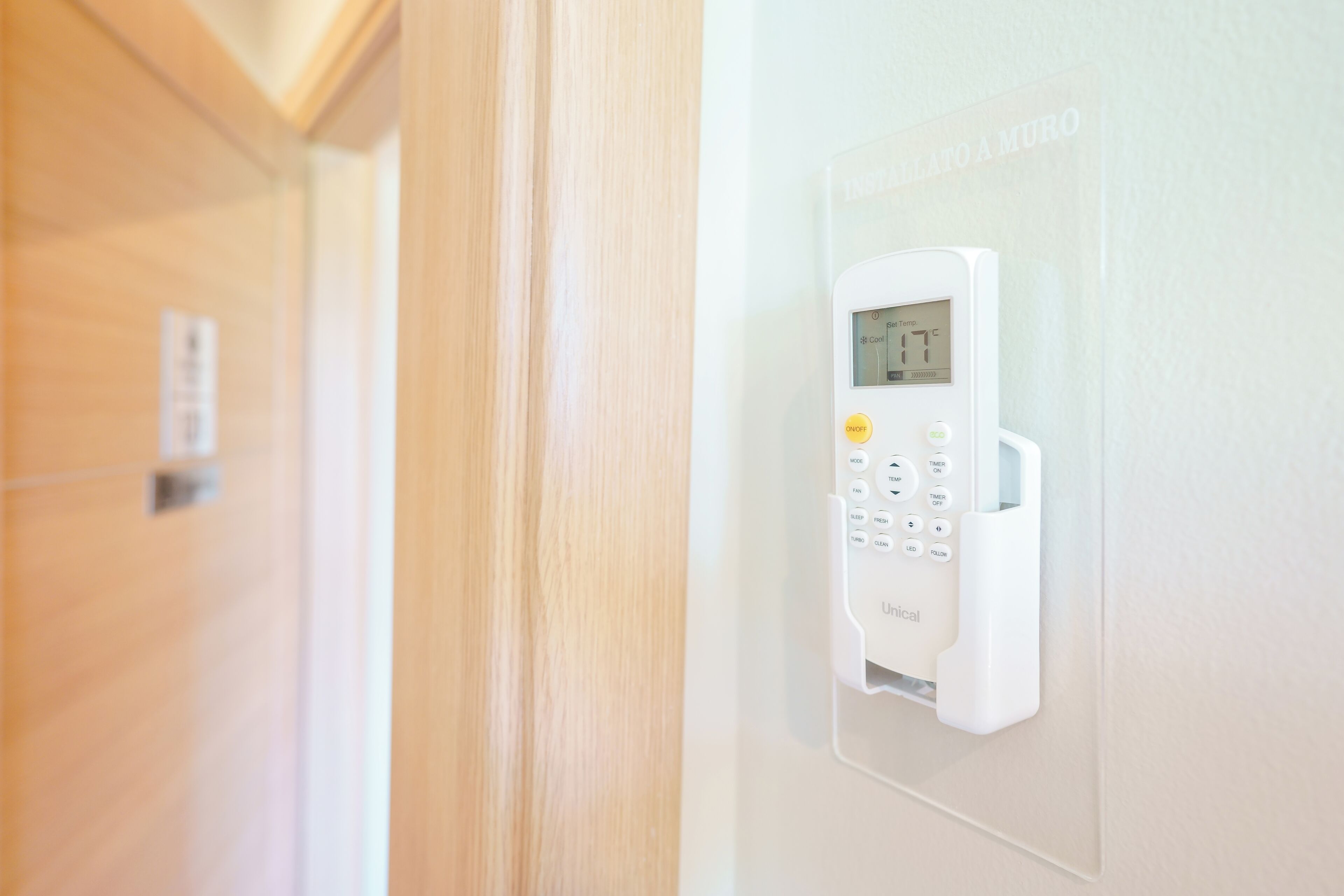 A wall-mounted electronic device with a keypad and a display screen, likely a security or control panel.