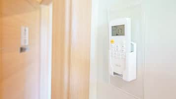 A wall-mounted electronic device with a keypad and a display screen, likely a security or control panel.