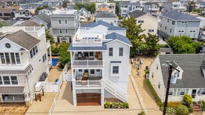 A multi-story residential building with a balcony, a small deck, and a visible garage.