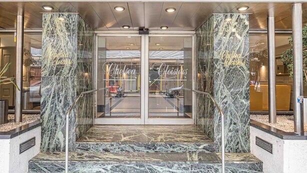 A hotel entrance with marble columns, glass doors, and a metal staircase. - Stylish studio/ Harrods /South Kensington /Chelsea/Central London (London)