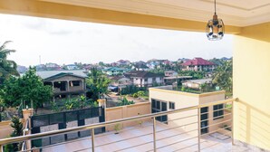 Un balcón con vista a una zona residencial, con casas y vegetación.
