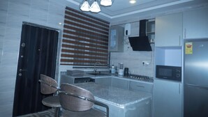 Una cocina moderna con electrodomésticos de acero inoxidable, una isla central y un comedor con sillas.