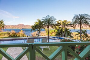A pool area with a view of the ocean and mountains.