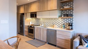 Una cocina moderna con armarios de madera, microondas, estufa y cafetera.