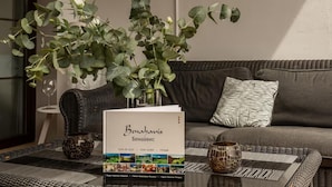 A cozy living area with a sofa, a coffee table, and a book titled 'Benhalavís'. - 2 Bedrooms - Sleeps 4 - Garden and Pool With View (Benahavis)