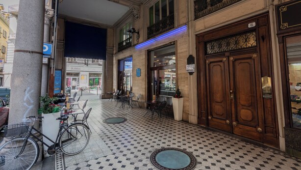 Un espace intérieur doté d’un sol carrelé, d’une porte en bois et d’un vélo.