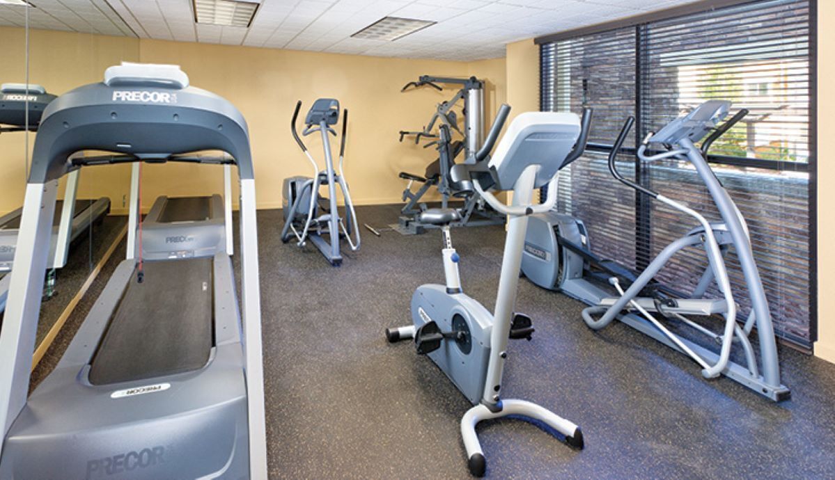 Ein Fitnessstudio mit Laufbändern, Crosstrainern und Gewichtsmaschinen.