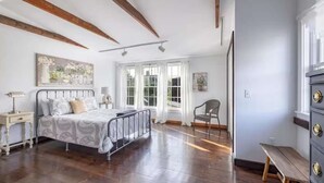 Un dormitorio con cama, mesita de noche, silla y cómoda.