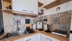 A modern kitchen with white cabinets, a stainless steel sink, a coffee maker, and a toaster. - Cycladic Home with a view  - 2 min walk from the beach!  (Adamantas)
