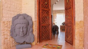 Ein Durchgang mit aufwendigen HolzSchnitzereien und einer Buddha-Kopf-Skulptur auf der linken Seite.