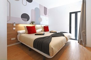 Quarto moderno com uma cama grande, mesas de cabeceira, telefone fixado na parede e janela com cortinas.