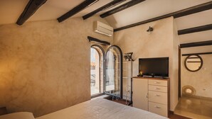 Ein Schlafzimmer mit Bett, Fernseher, Kleiderschrank und Fenster mit Blick.
