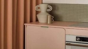 A kitchen with a pink cabinet, a small countertop, and a microwave. - Pops Apartment

 (Kraków)