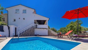 A white building with a swimming pool, a red umbrella, and a stone staircase. - Holiday house CHARMING with private pool (Kras)