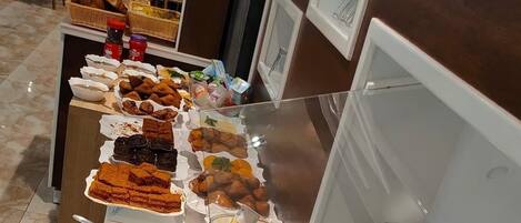 A buffet with various food items including fruits, vegetables, and desserts.
