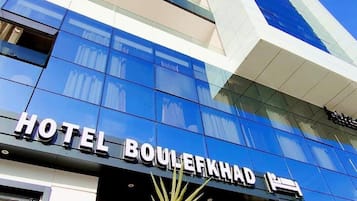 Fachada moderna de un hotel con el nombre "HOTEL BOULERKHAD" claramente visible.