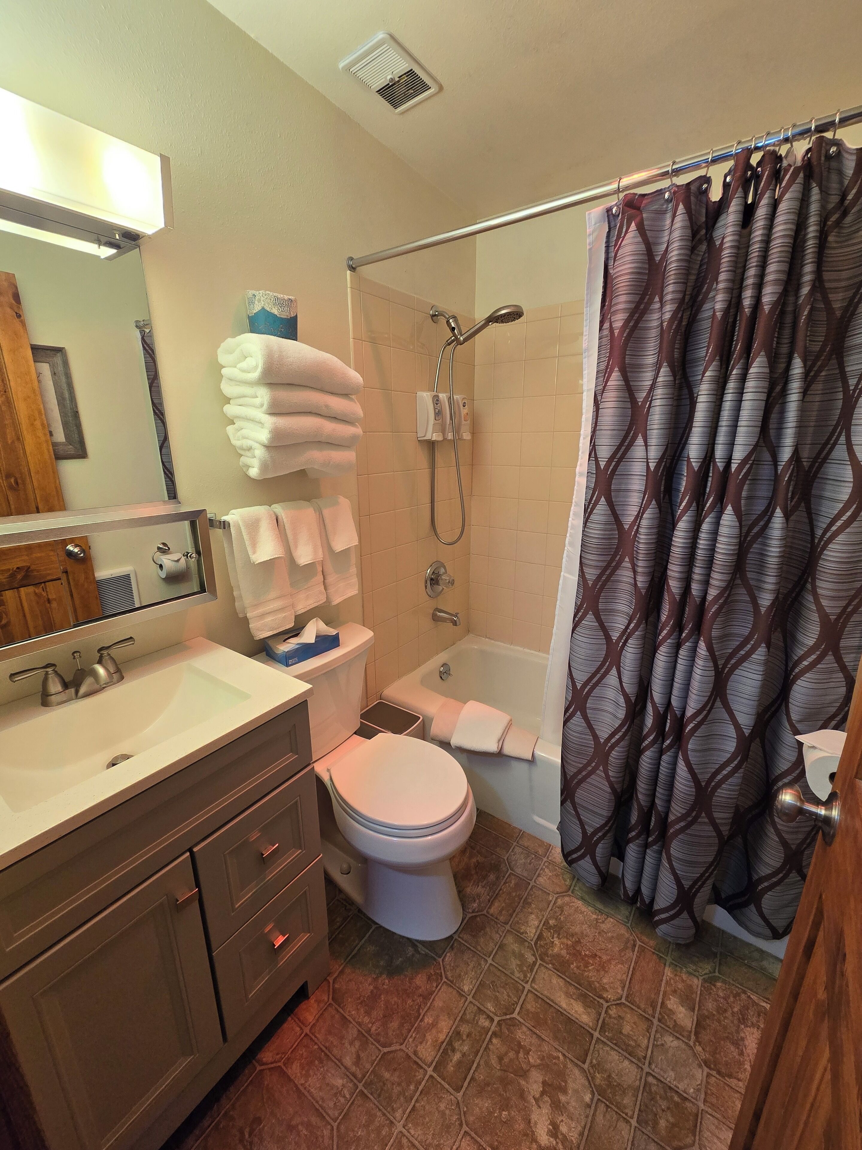 A bathroom with a sink, toilet, and shower.