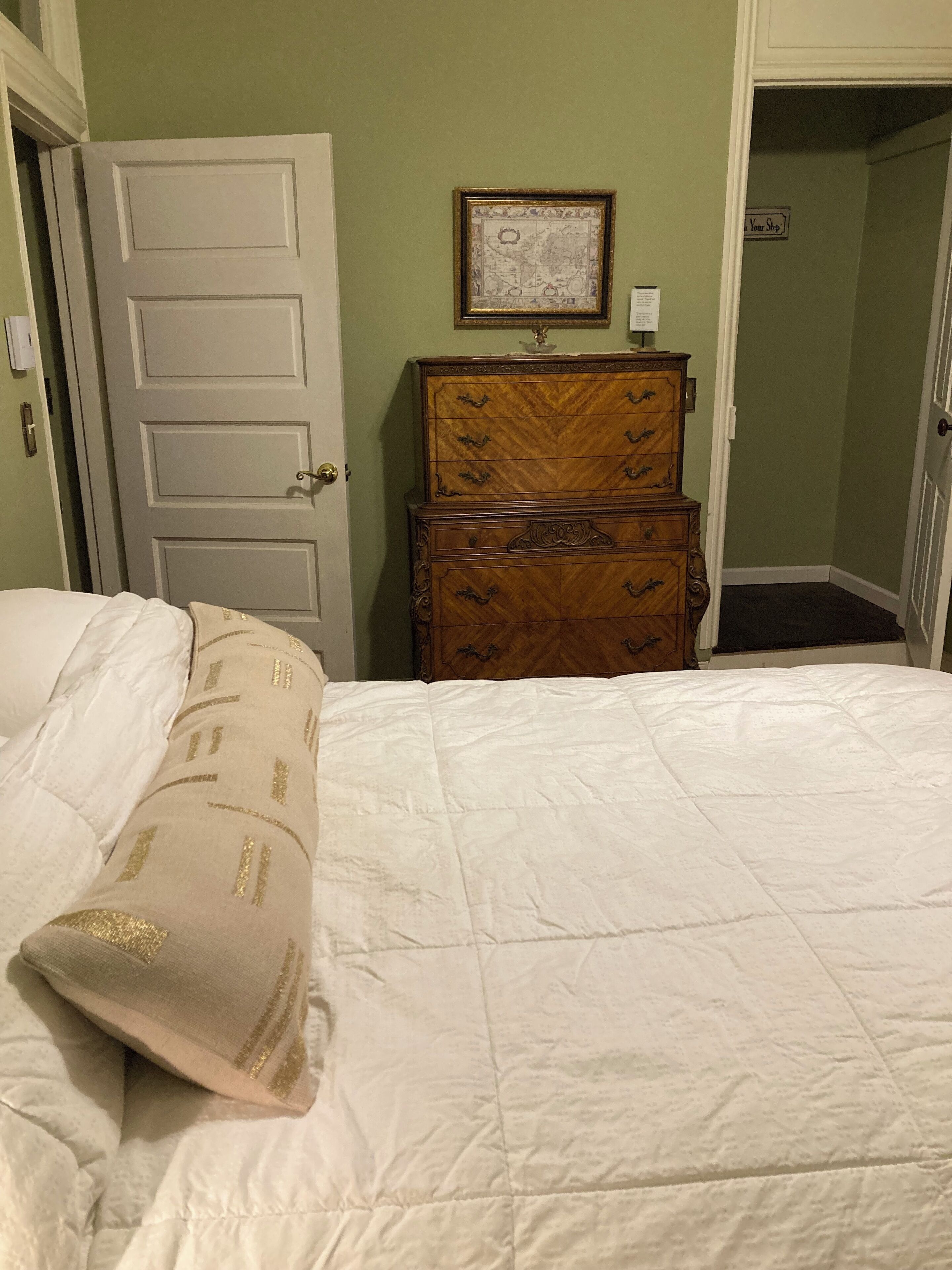 Une chambre à coucher avec un lit, une commode et une porte.