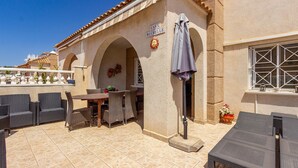 Une terrasse extérieure avec des meubles en osier, un sol carrelé et une enseigne indiquant « CASA MICHELLE ».