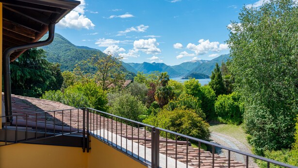 A balcony with a view of a mountainous landscape and a lake.